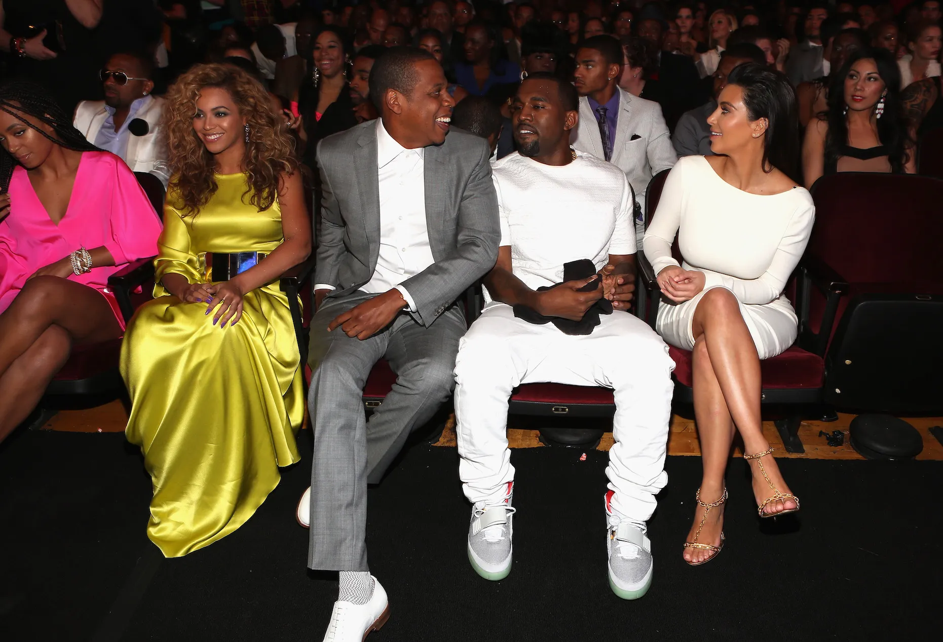 Beyoncé, Jay-Z, Kanye West, and Kim Kardashian attend the 2012 BET Awards at The Shrine Auditorium on July 1, 2012. They're all sitting next to each other and laughing. A crowd sits behind them.