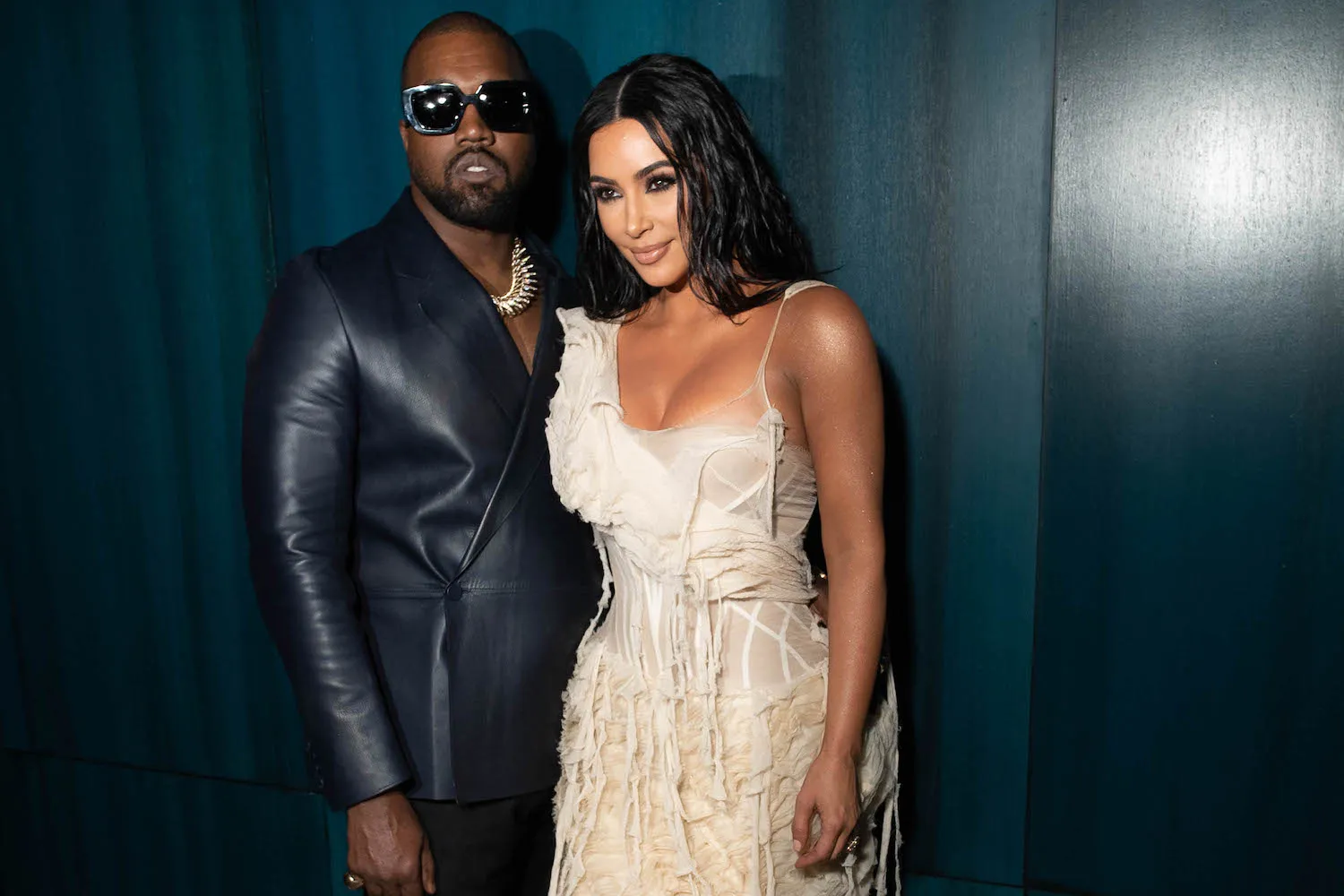 Kanye 'Ye' West in a suit and Kim Kardashian in a white dress posing in 2020