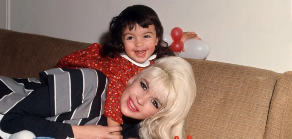 Young Mariska Hargitay with her mom Jayne Mansfield on a couch