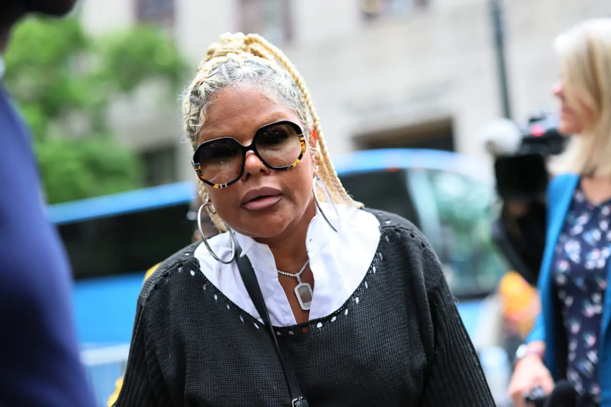 Misa Hylton wears a sweater over a white shirt and sunglasses.