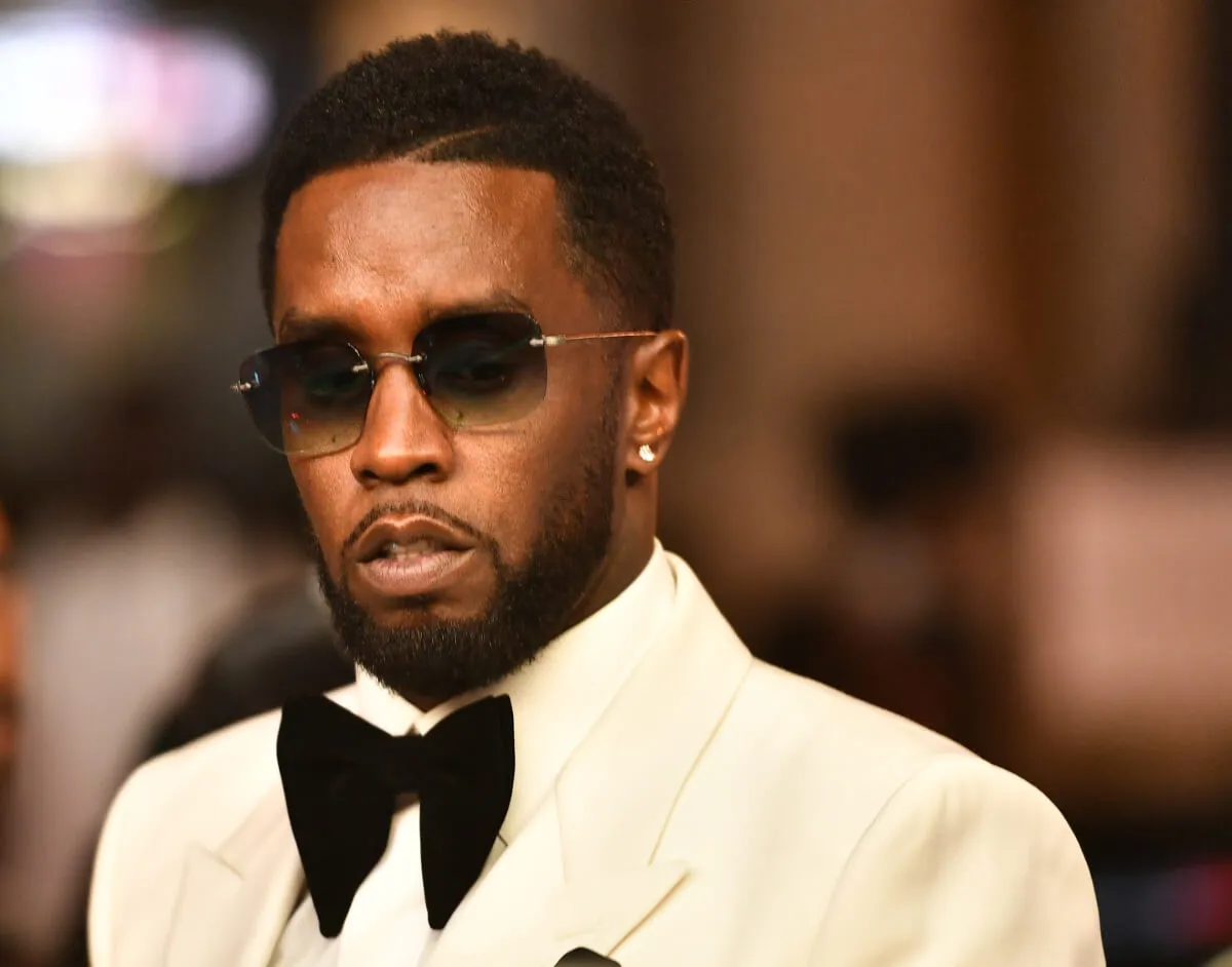 Sean 'Diddy' Combs wears a white tuxedo and sunglasses.